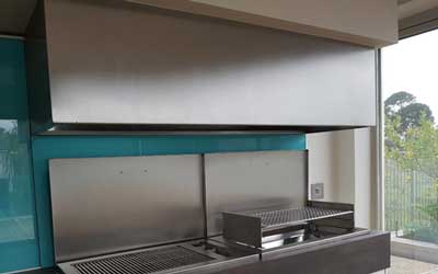 This hood is hanging above a combination of gas and wood drop-in braais. 