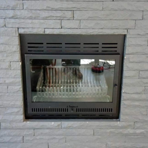 AFTER - Custom frame and door added to steel fireplace turning it into a slow-burner.