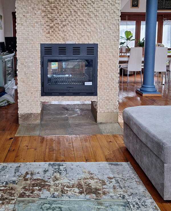 Custom frame with glass door added to an existing steel fireplace turning it into a slow-burner.
