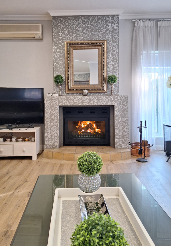 Custom frame with glass door added to an existing steel fireplace turning it into a slow-burner.
